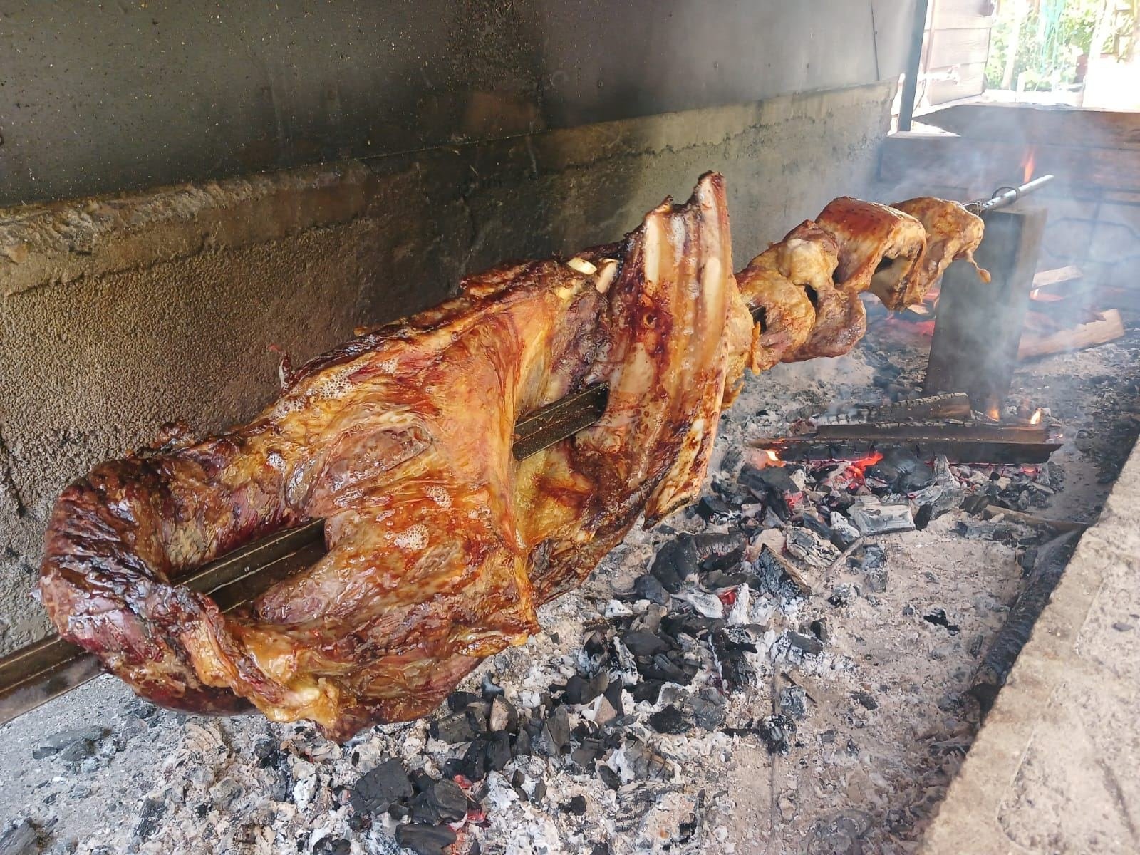 Spit-roasted lamb over the coals of the quincho
