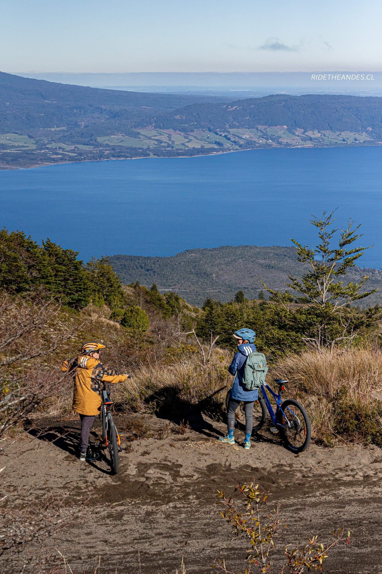 Dos ciclistas descansan en un mirador sobre un lago