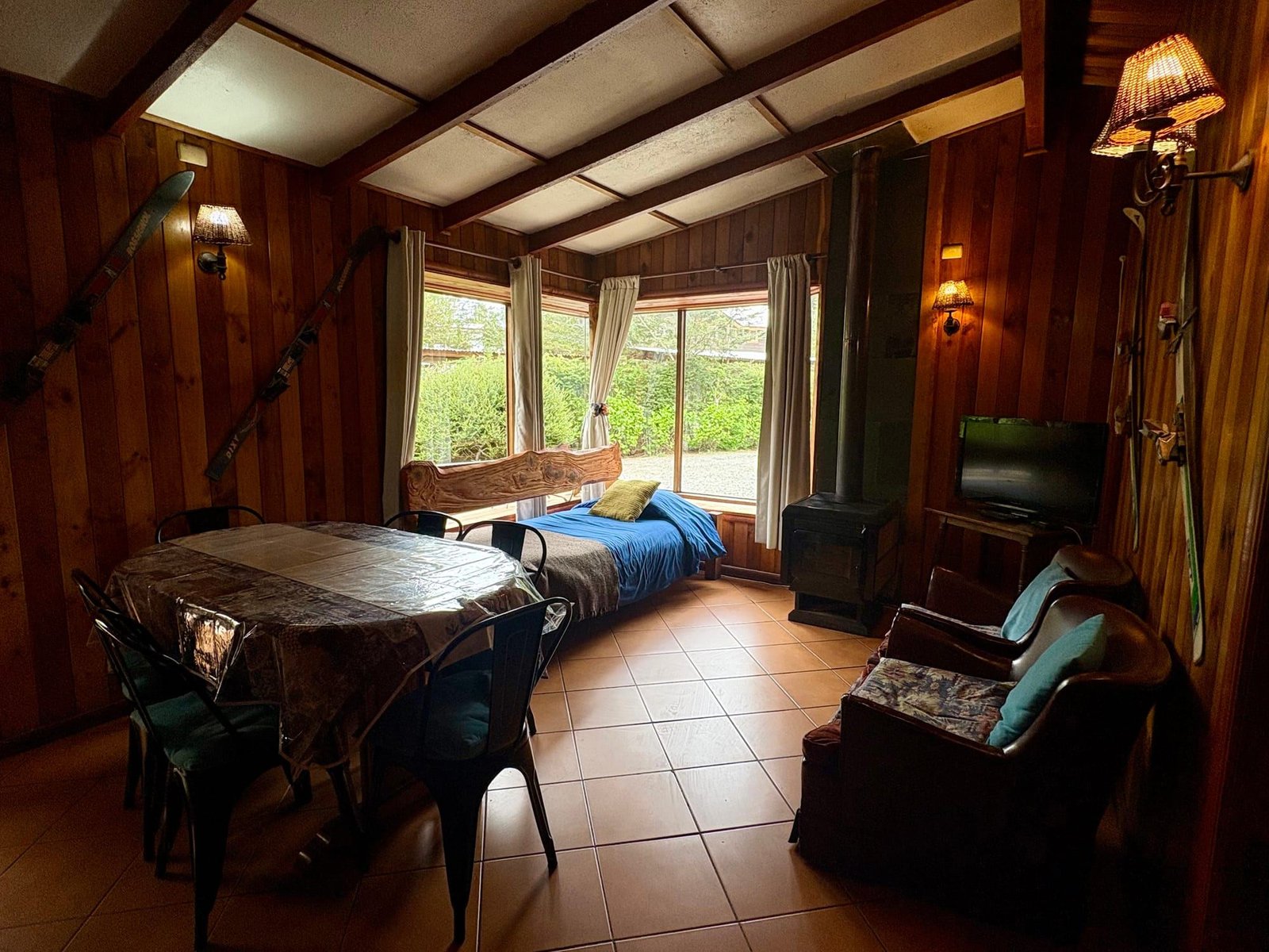 A cabin living-dining room with a table, a sofa bed and a large window