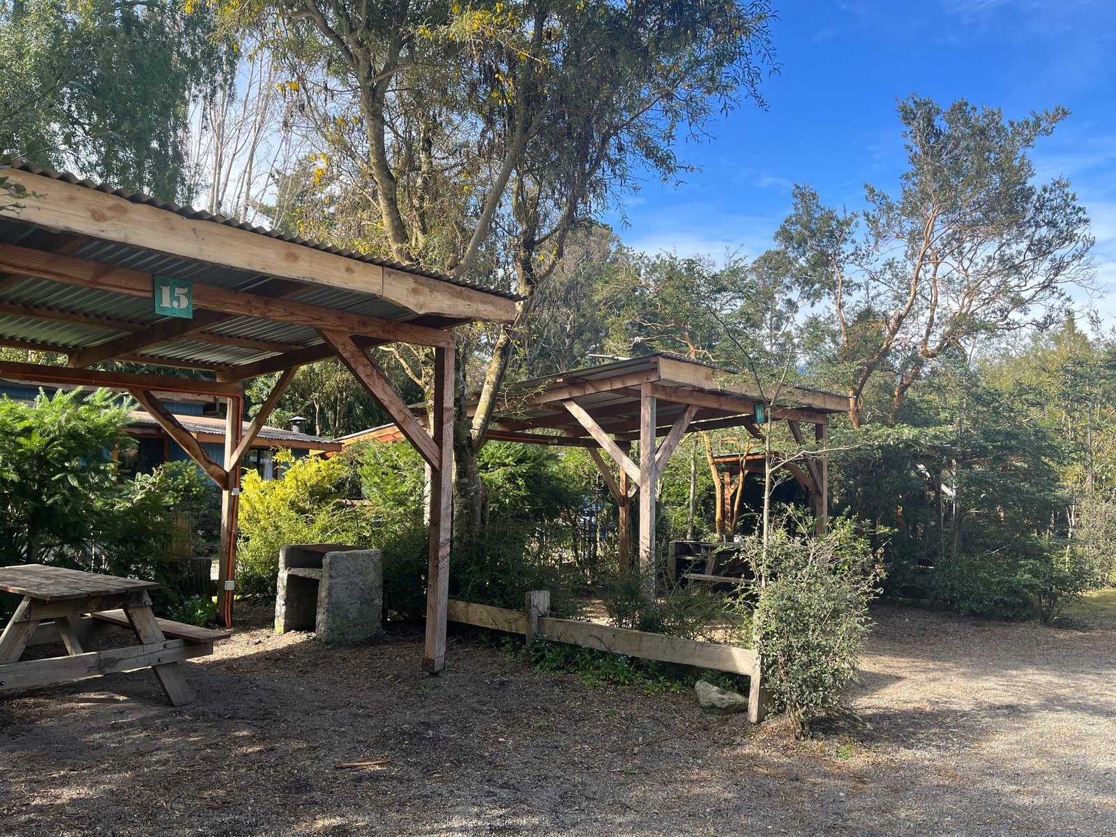 Covered campsites with picnic tables among the trees