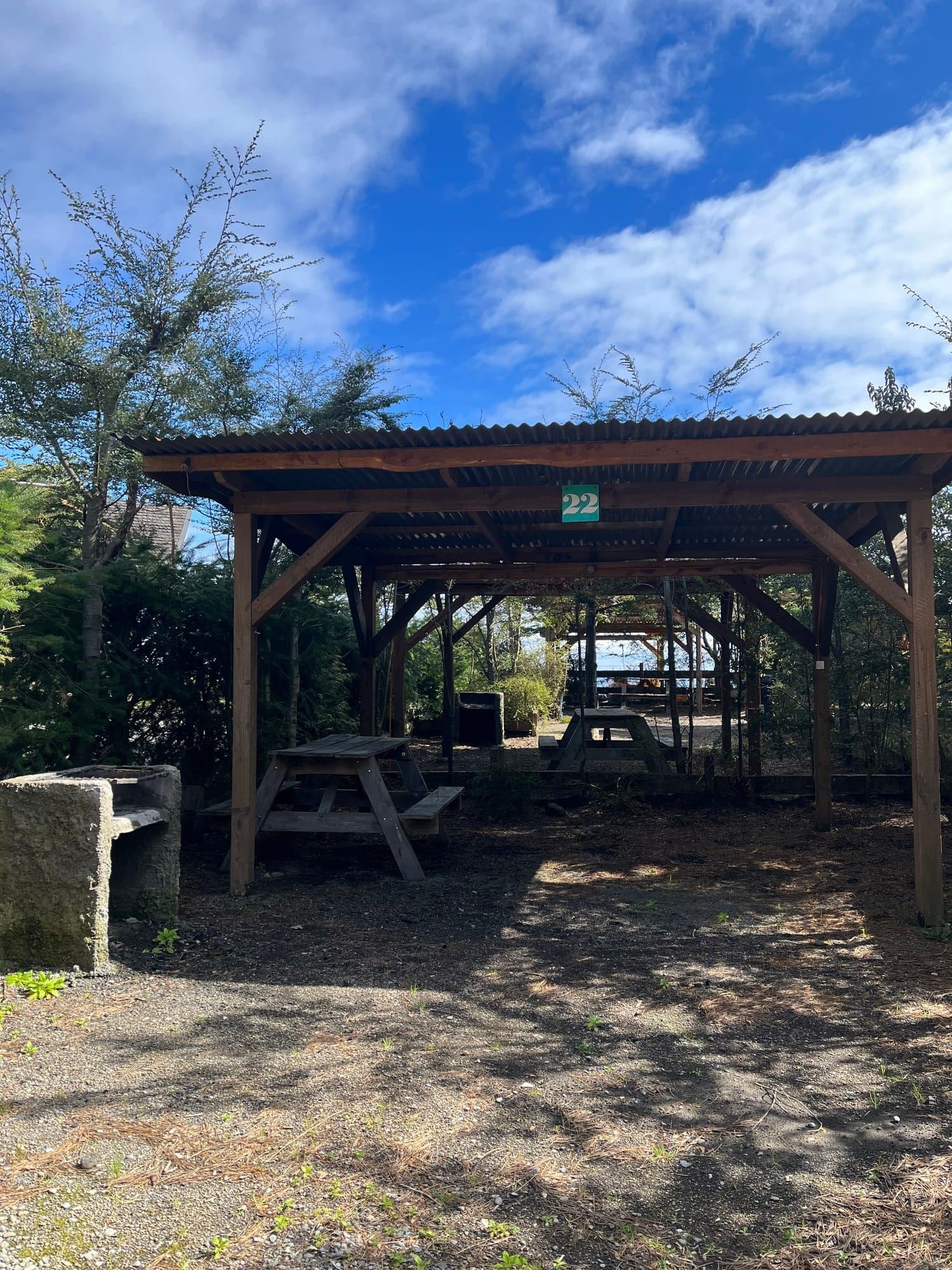 Sitio de camping techado con mesón y parrilla