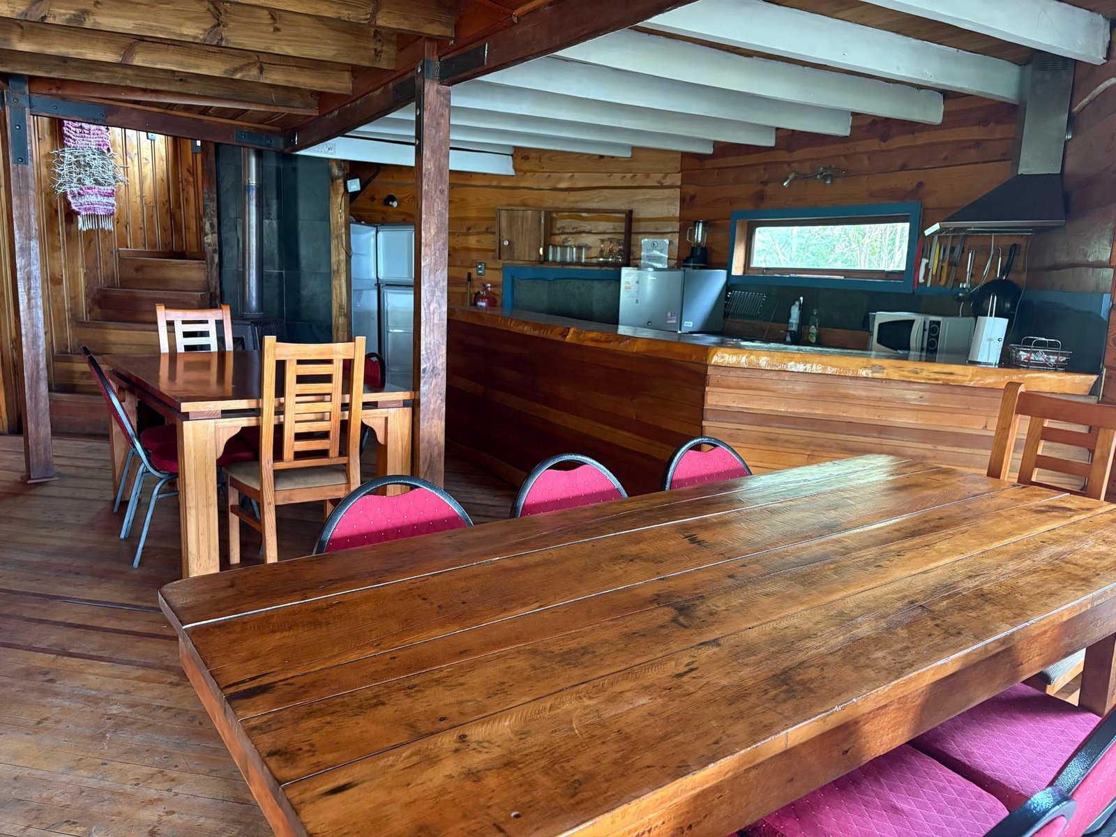 The beach house dining room with a long wooden table and an open kitchen