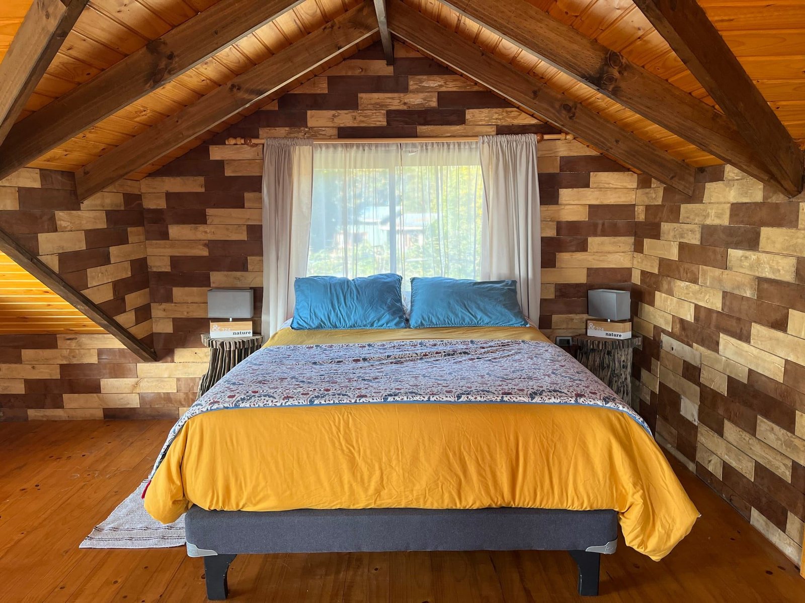 A double bedroom in the beach house, under the beamed roof