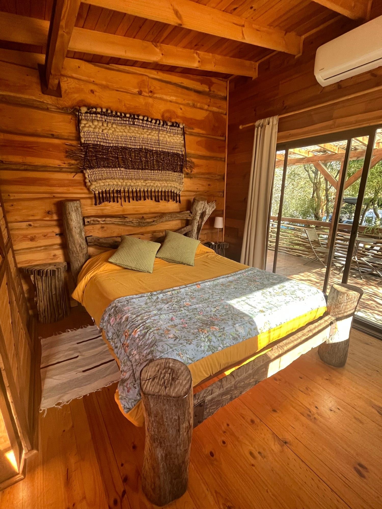 An apartment with a double bed and a window onto the terrace