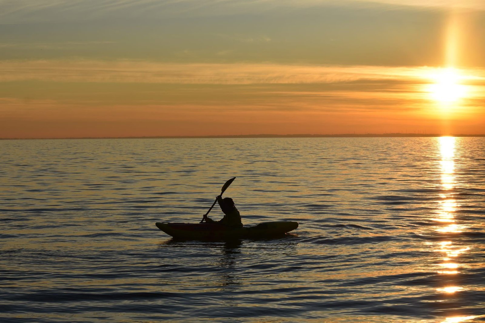 Silueta de una persona en kayak al atardecer en el Lago Llanquihue