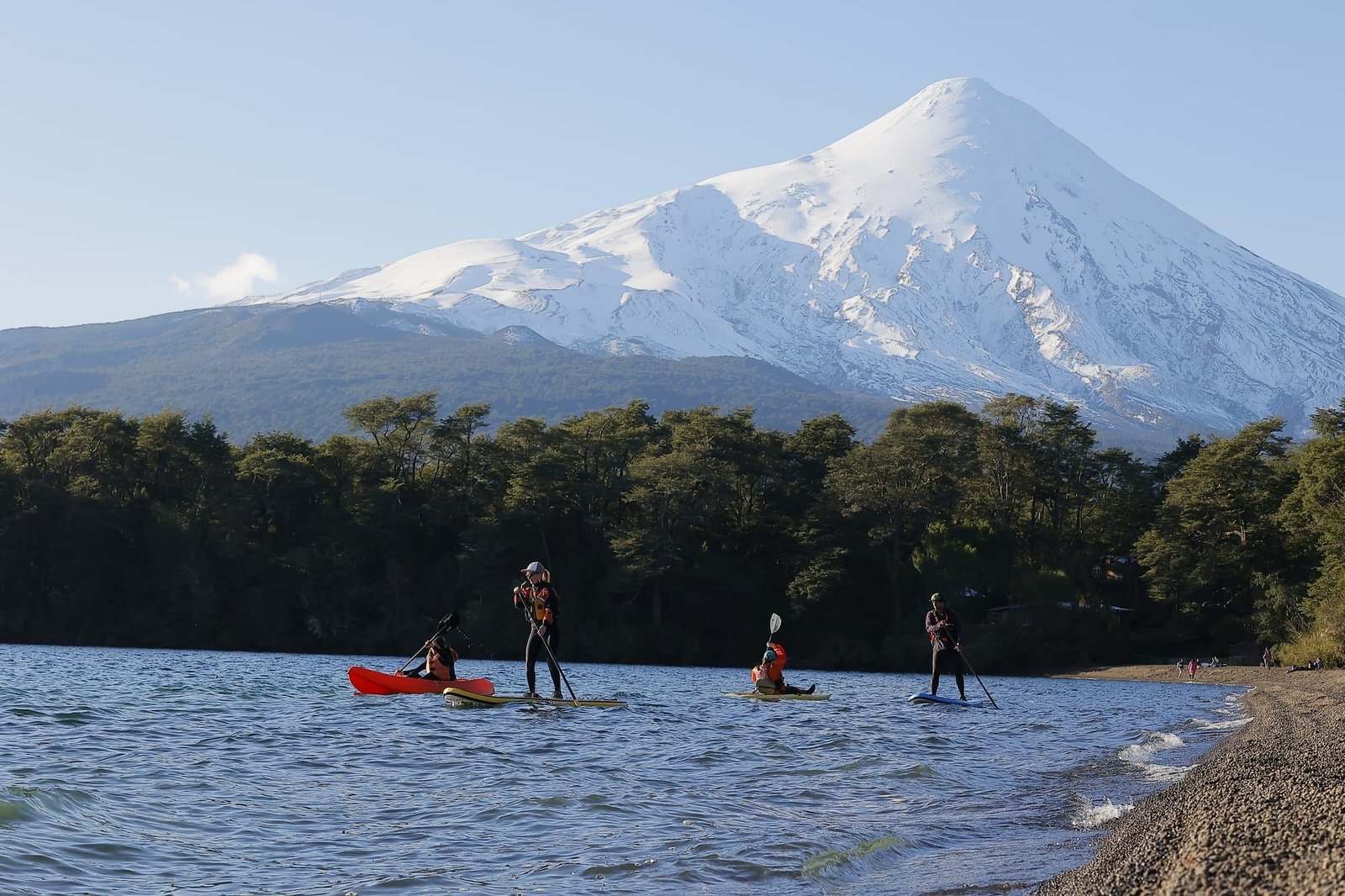 Personas en kayak y stand up paddle en el Lago Llanquihue, con el volcán Osorno nevado