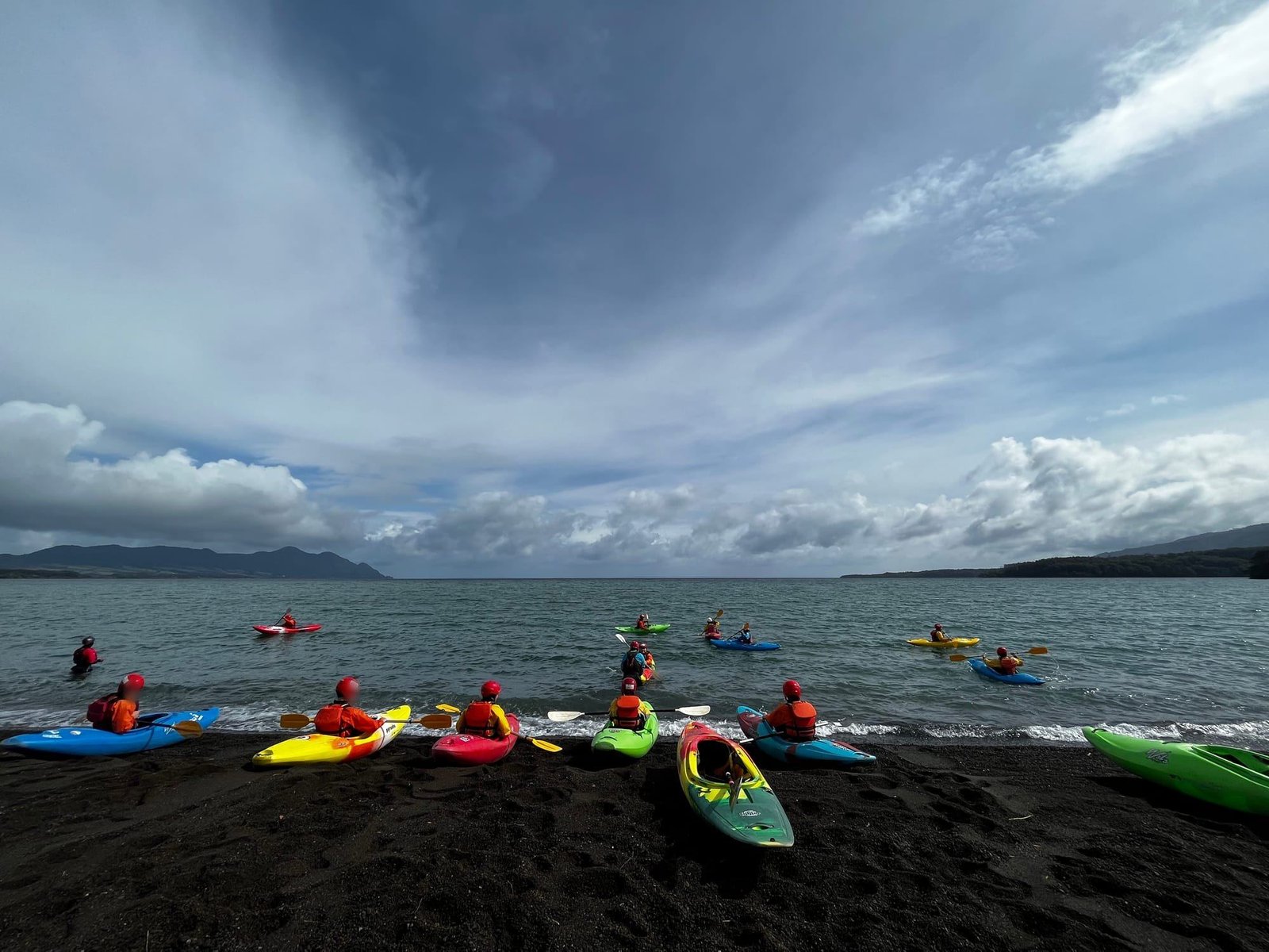 Colorful kayaks head out onto Lake Llanquihue from the beach