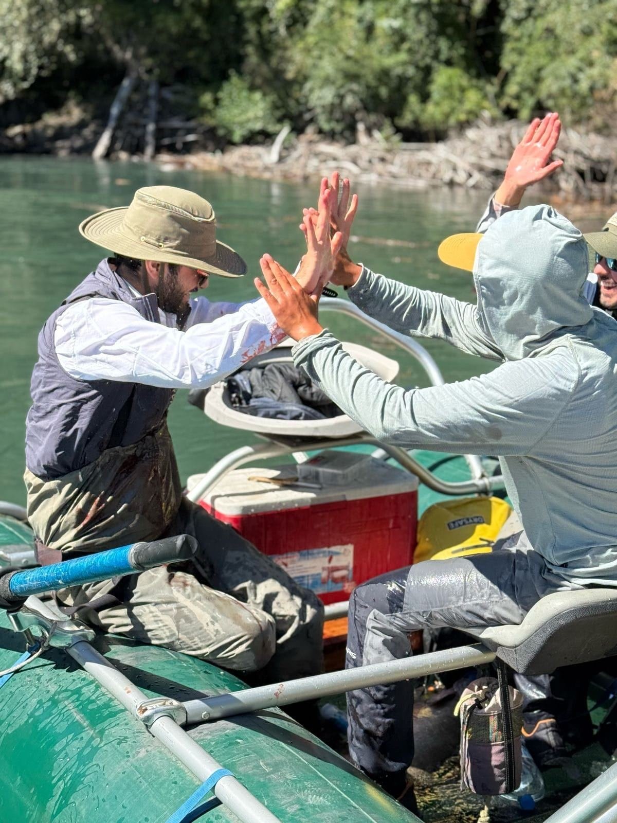 Dos pescadores celebran en un bote de pesca en el río