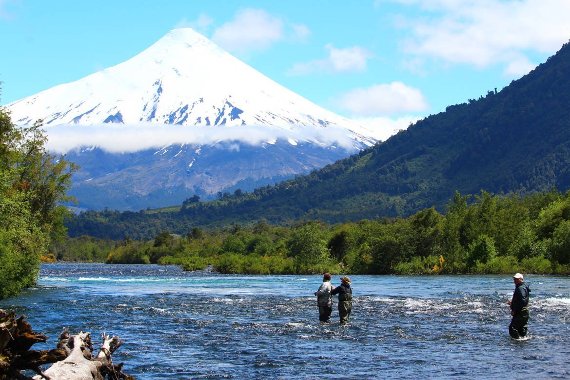 Pescadores con mosca en el Río Petrohue con el volcán Osorno nevado de fondo