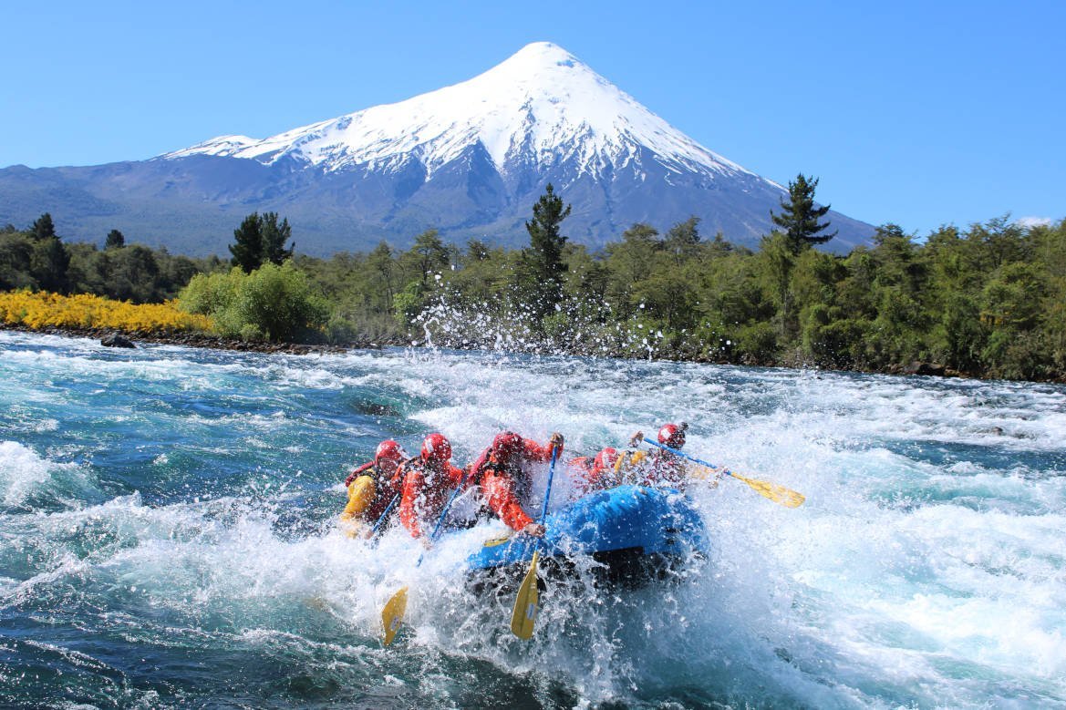 Balsa de rafting en un rápido con el volcán Osorno de fondo