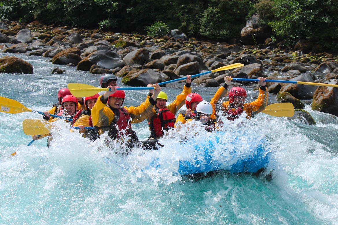 Group celebrating with paddles up after a rapid