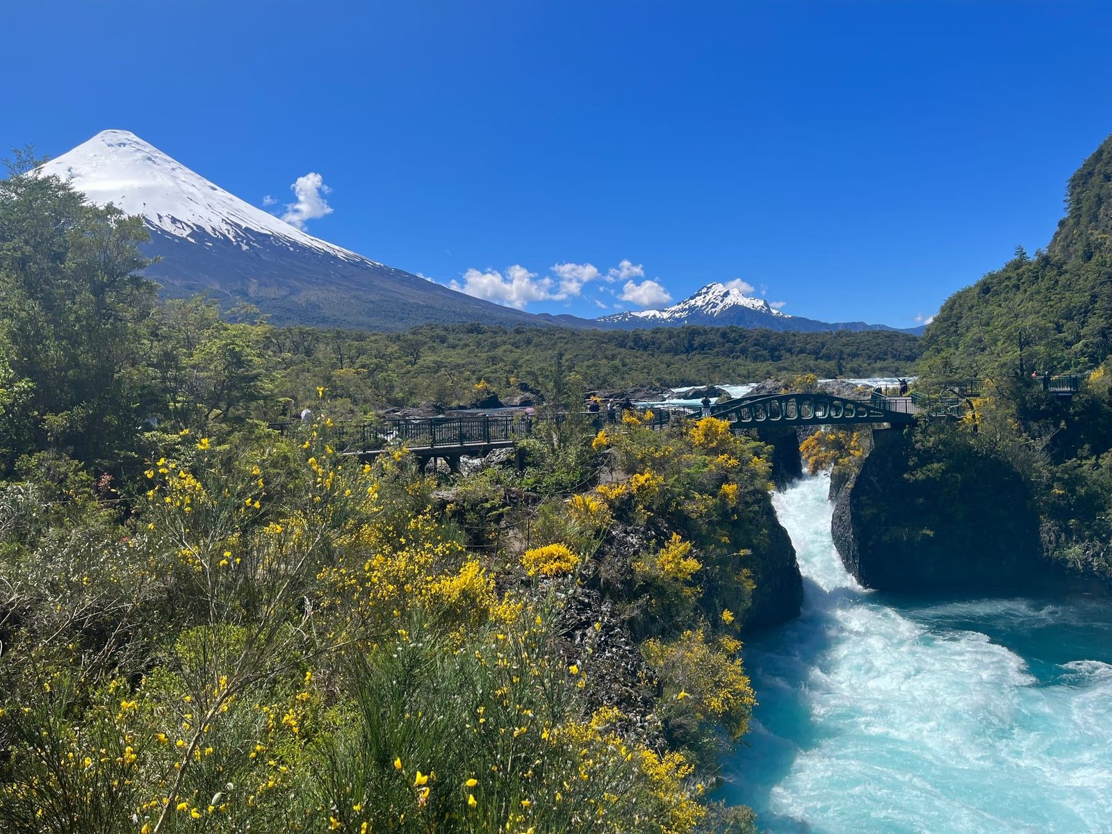 Saltos del Petrohué entre roca volcánica, con el volcán Osorno nevado al fondo