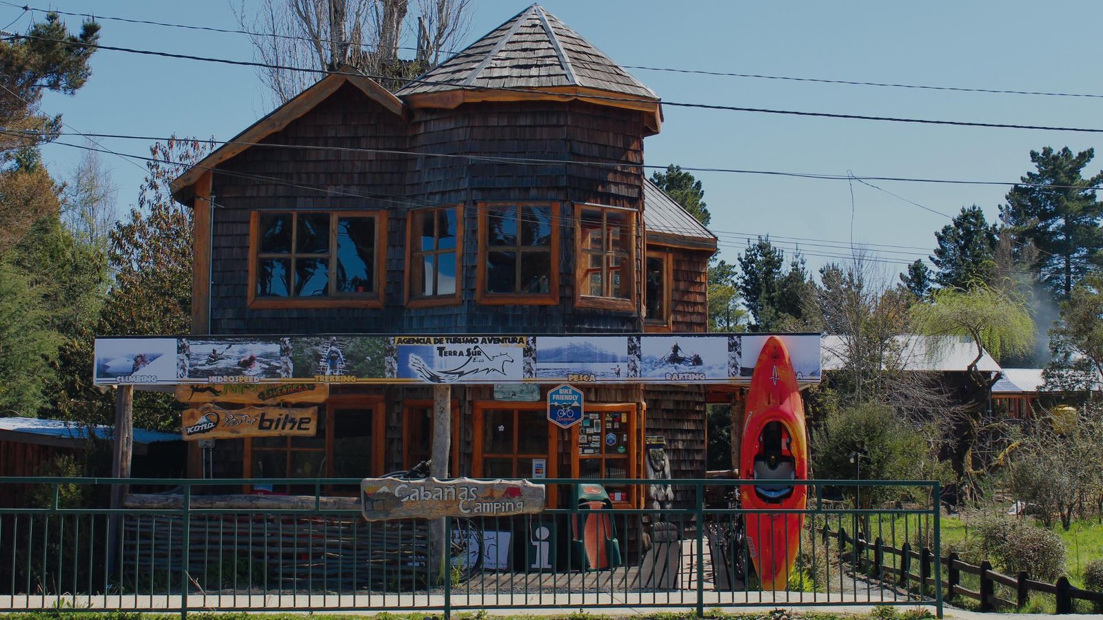 Casa de madera de la base de TerraSur en Ensenada, con letrero de cabañas y camping