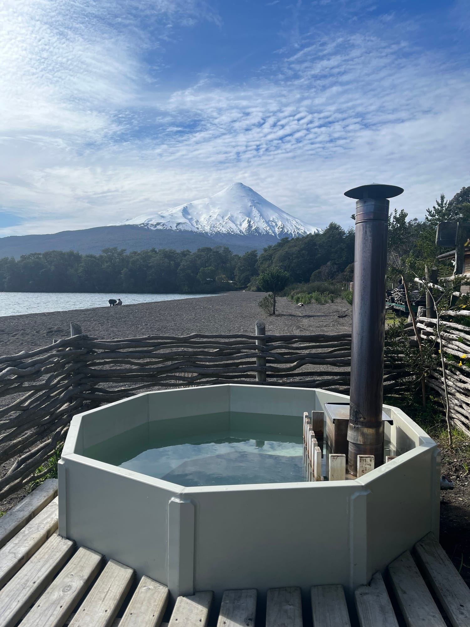 A wood-fired hot tub facing Lake Llanquihue, with snow-capped Osorno Volcano