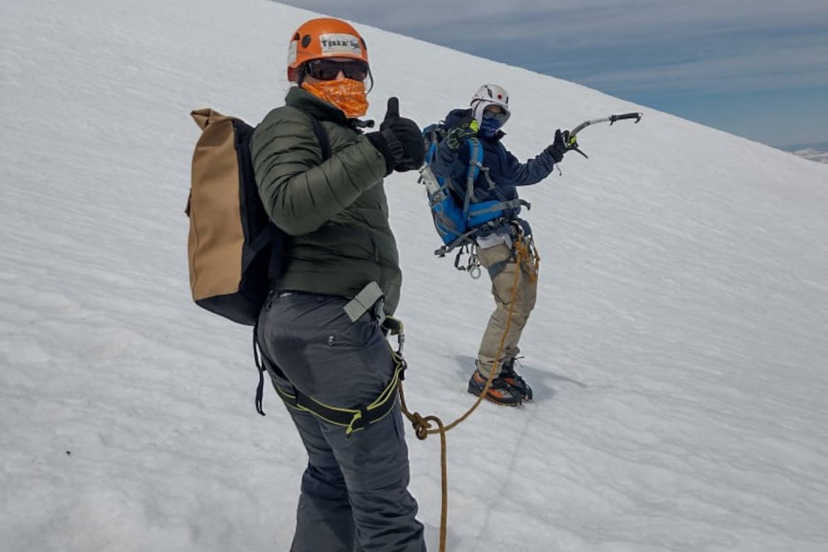 Two roped climbers going up the glacier with ice axes